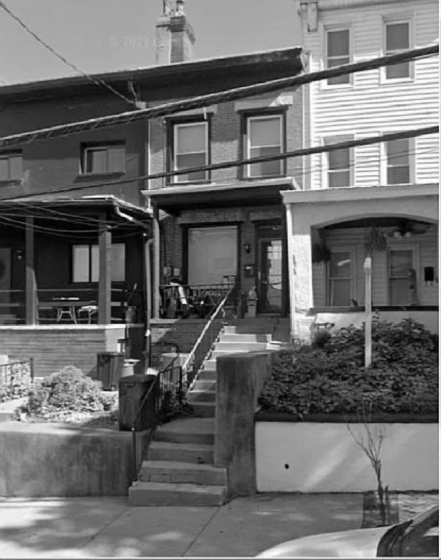 Black and white image of a townhome on a city street.